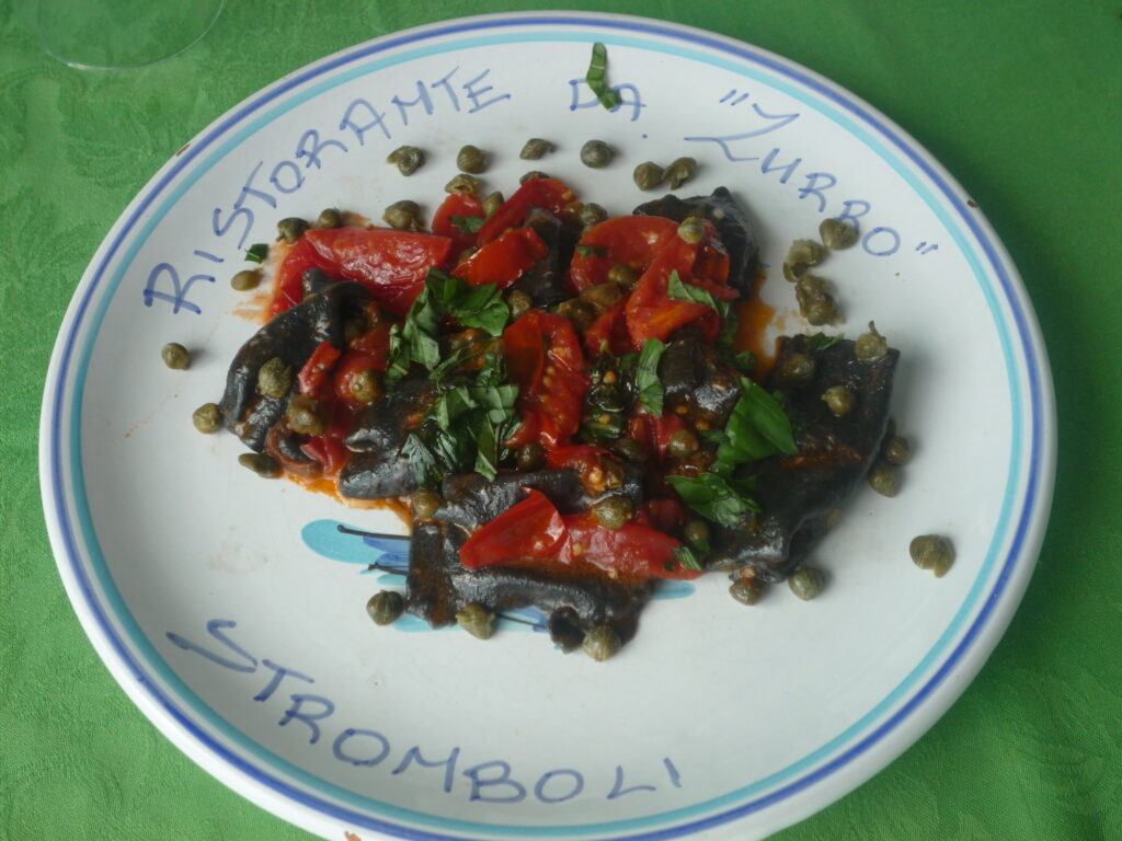Ein Augenschmaus: dunkle Pasta mit Tintenfisch, kleinen Tomaten, Kapern und Basilikum